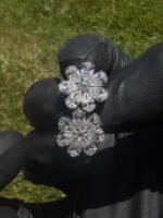 Earrings held in fingers over grass - 4 CTW Pear-Shaped Lab-Grown Diamond Flower Earrings - 14K White Gold