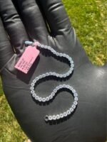 Solid 14K white gold tennis bracelet with 4.45 CTW lab-grown diamonds held on a gloved hand outdoors