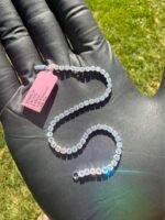 Solid 14K white gold tennis bracelet with 4.45 CTW lab-grown diamonds on a gloved hand with a pink tag, full view